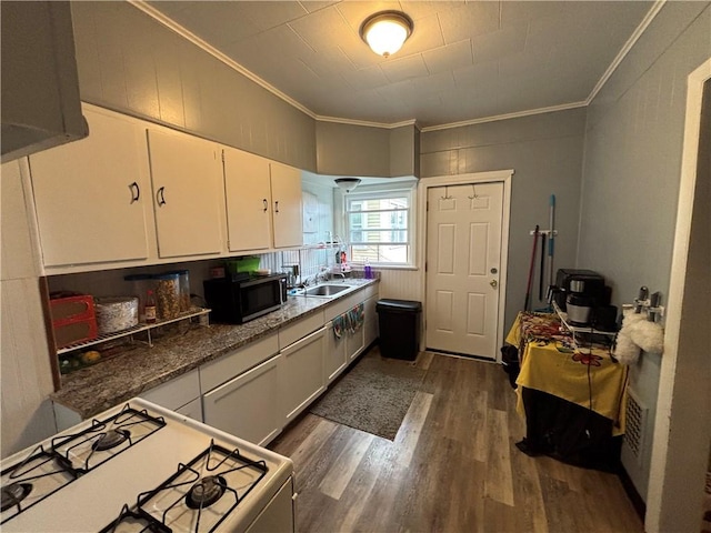 kitchen featuring white cabinets, ornamental molding, gas range gas stove, and dark wood-type flooring