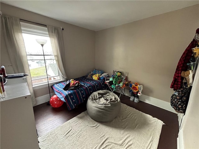 bedroom with baseboards and wood finished floors