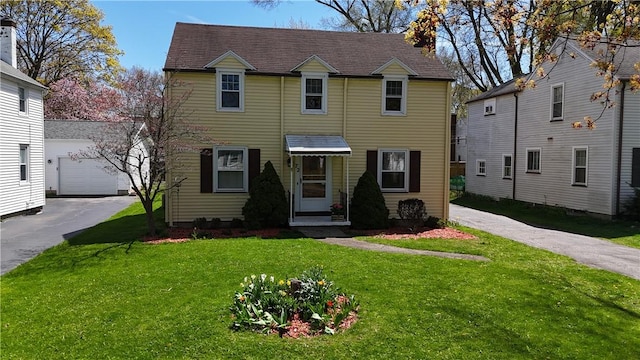 view of front of property with a chimney and a front lawn