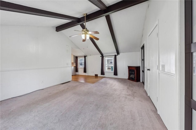 unfurnished living room with a ceiling fan, vaulted ceiling with beams, carpet, and a fireplace