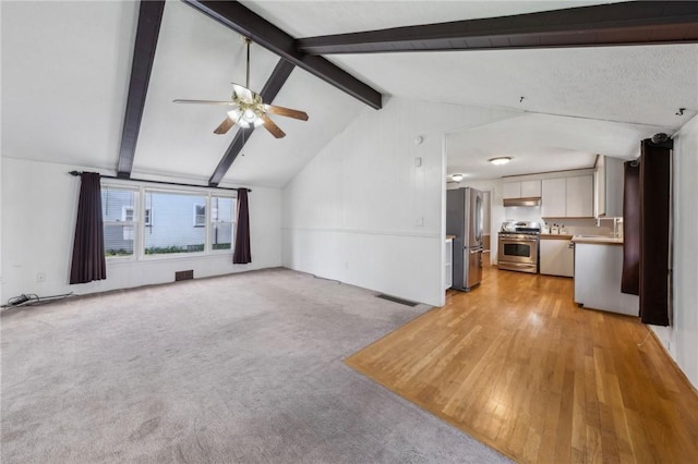 unfurnished living room with ceiling fan, visible vents, light wood-type flooring, a sink, and vaulted ceiling with beams