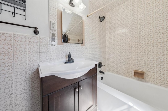 full bathroom featuring vanity, tile walls, and bathtub / shower combination