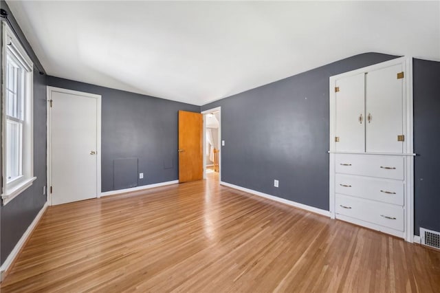 unfurnished bedroom with baseboards, light wood-style flooring, and visible vents