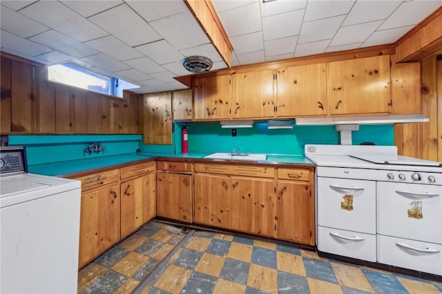 kitchen featuring washer / dryer, light countertops, tile patterned floors, a sink, and double oven range