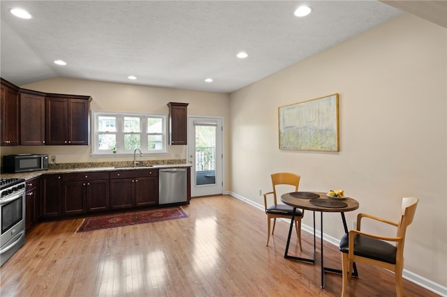 kitchen with light wood-type flooring, a sink, appliances with stainless steel finishes, and dark brown cabinets