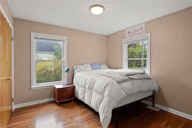 bedroom featuring baseboards and wood-type flooring
