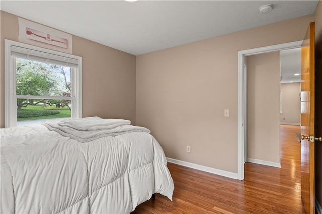 bedroom with baseboards and wood finished floors