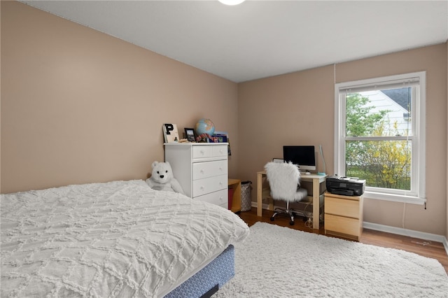 bedroom with baseboards and wood finished floors