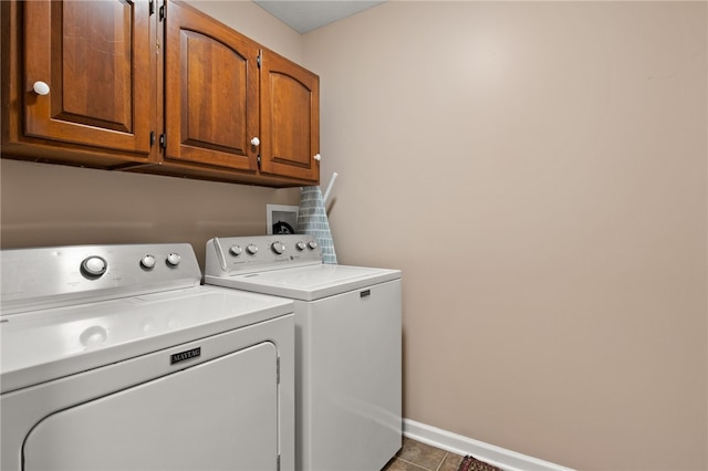 laundry area featuring baseboards, tile patterned flooring, cabinet space, and washing machine and dryer
