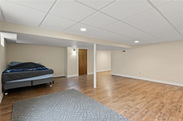 interior space featuring baseboards, recessed lighting, wood finished floors, and a paneled ceiling