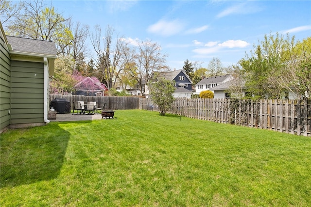view of yard featuring a patio, a fenced backyard, a fire pit, and a residential view