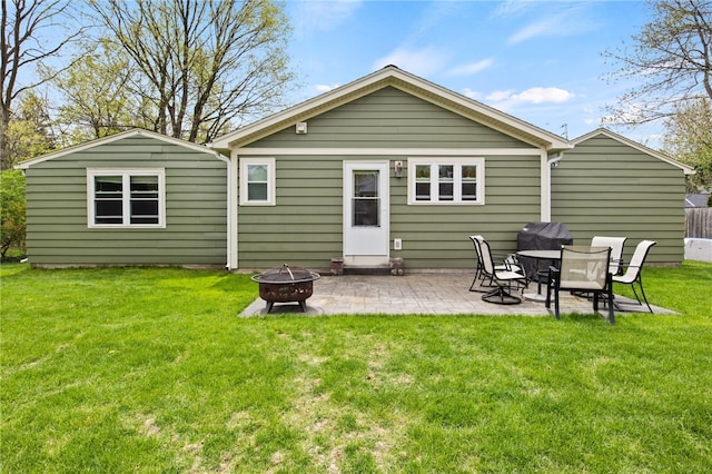 back of property featuring a lawn, a fire pit, and a patio area