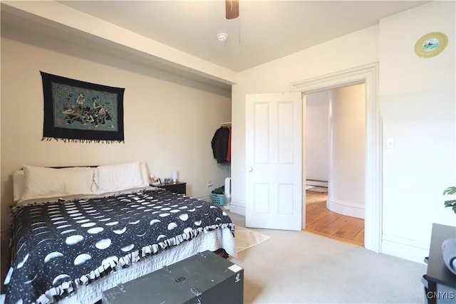 carpeted bedroom with a baseboard radiator and ceiling fan