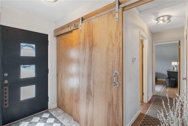 foyer featuring baseboards and a barn door