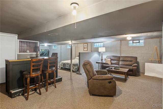 living room featuring concrete block wall, visible vents, a dry bar, and carpet