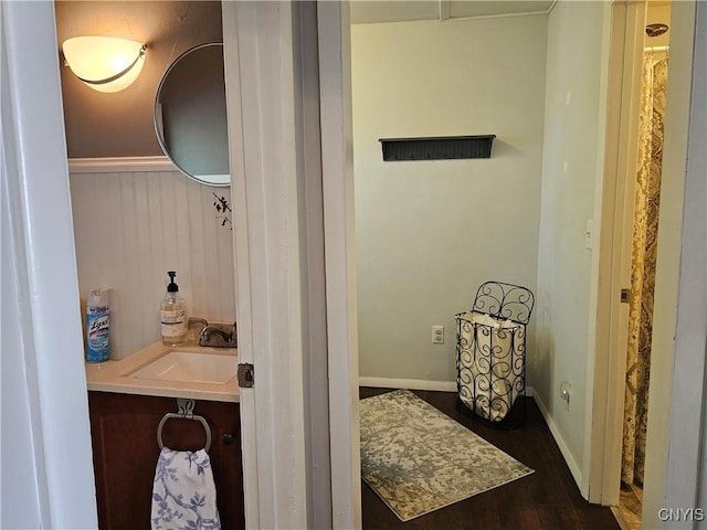 bathroom with vanity, baseboards, and wood finished floors