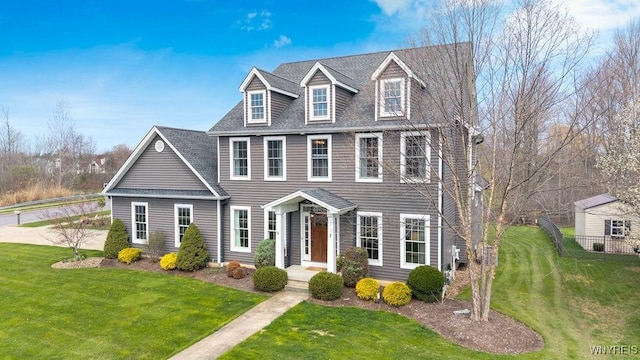 colonial-style house with roof with shingles and a front lawn