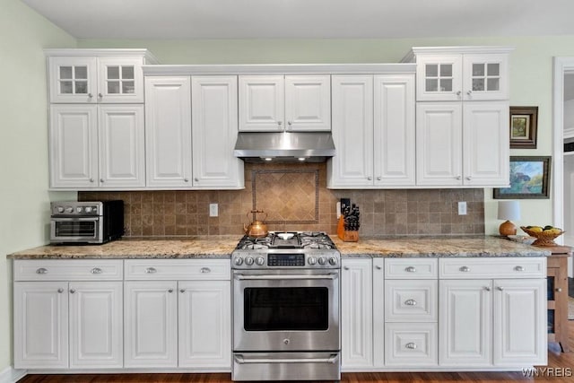 kitchen with gas stove, glass insert cabinets, white cabinets, and under cabinet range hood