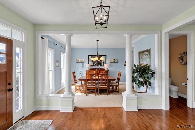 foyer featuring baseboards, plenty of natural light, wood finished floors, and a chandelier