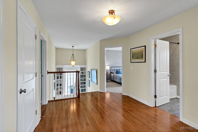 hallway with baseboards and wood finished floors