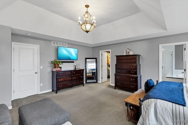 carpeted bedroom with a chandelier, baseboards, ensuite bathroom, a tray ceiling, and visible vents