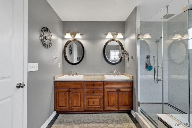 full bath featuring baseboards, a shower stall, and a sink