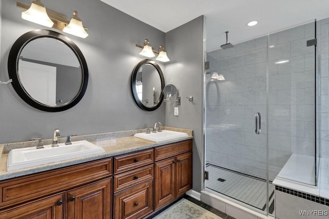 bathroom featuring double vanity, a sink, tile patterned flooring, and a shower stall