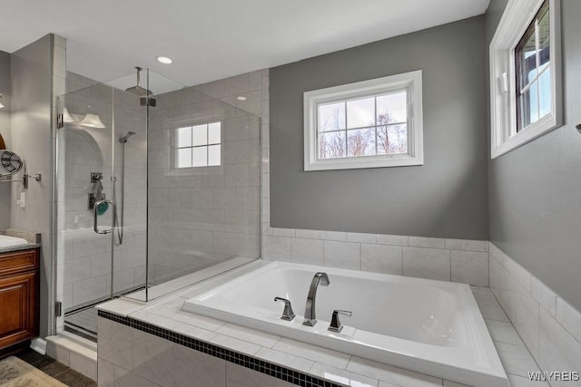full bathroom with a shower stall, a garden tub, and vanity
