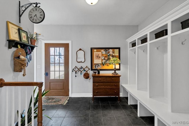 mudroom featuring dark tile patterned floors and baseboards
