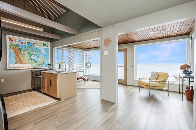 kitchen featuring light wood-style floors, light countertops, wooden ceiling, and a sink
