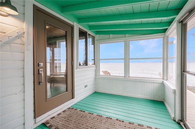 unfurnished sunroom with a water view, beam ceiling, and wood finished floors