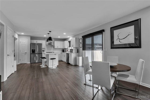 dining space featuring recessed lighting, baseboards, and dark wood finished floors