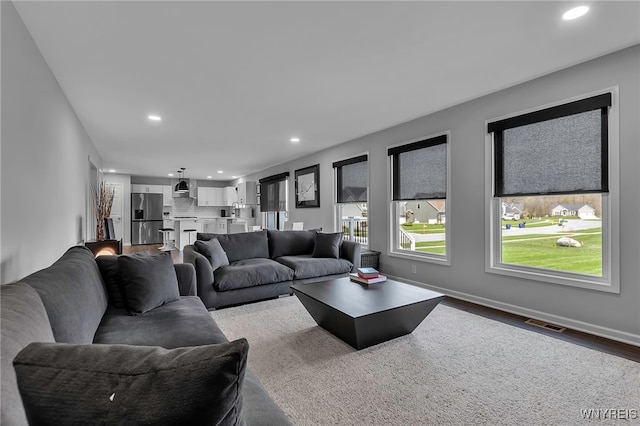 living area featuring baseboards, visible vents, recessed lighting, and dark wood-type flooring