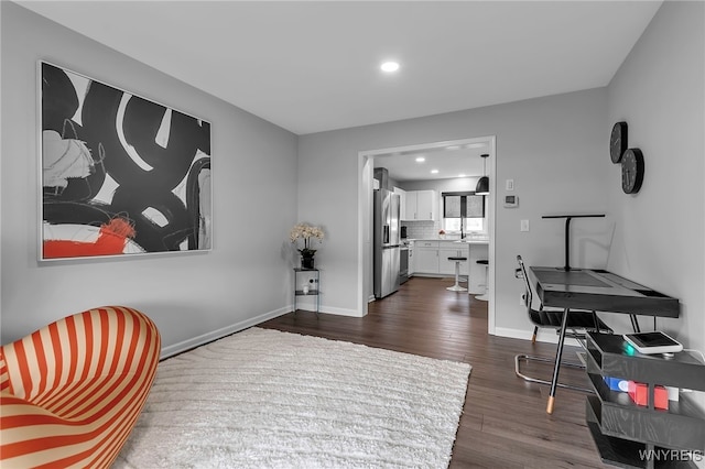 living area featuring baseboards, recessed lighting, and dark wood-type flooring