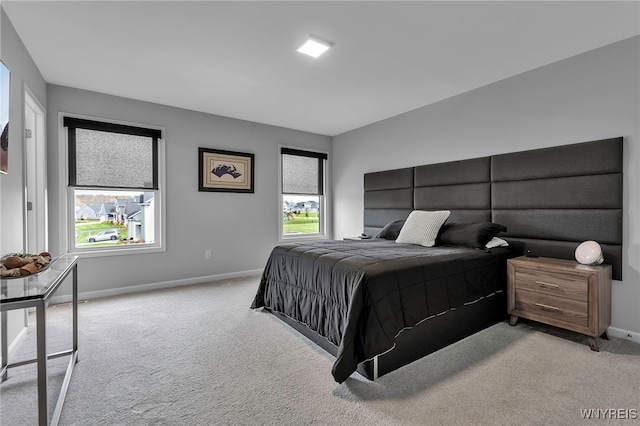 bedroom featuring baseboards and light colored carpet