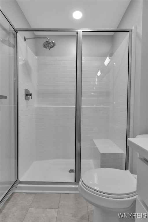 full bathroom with tile patterned floors, a stall shower, and toilet