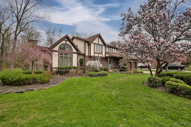 back of property with stucco siding, a yard, and a chimney