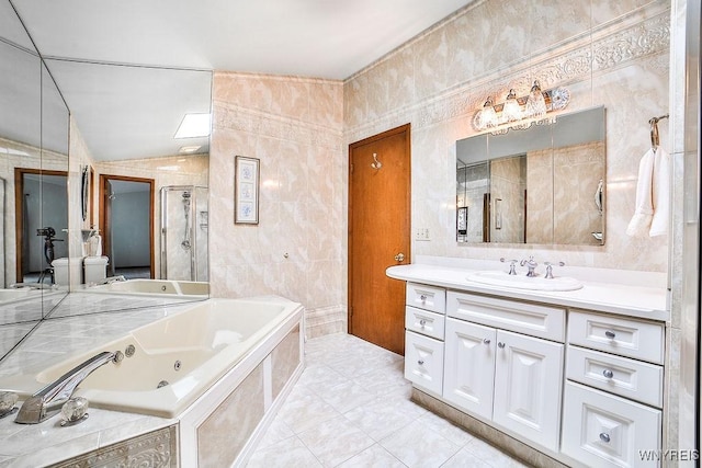 bathroom featuring vanity, a jetted tub, tile walls, vaulted ceiling, and a stall shower
