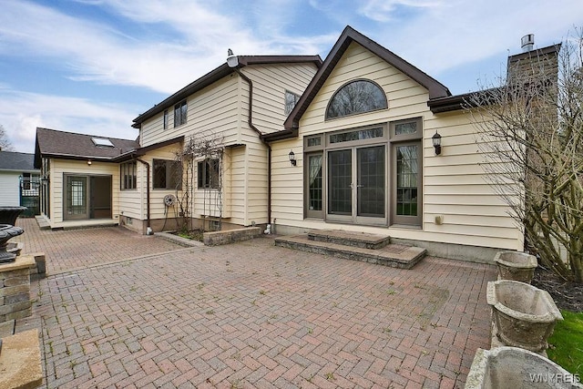 rear view of property with a patio and a chimney
