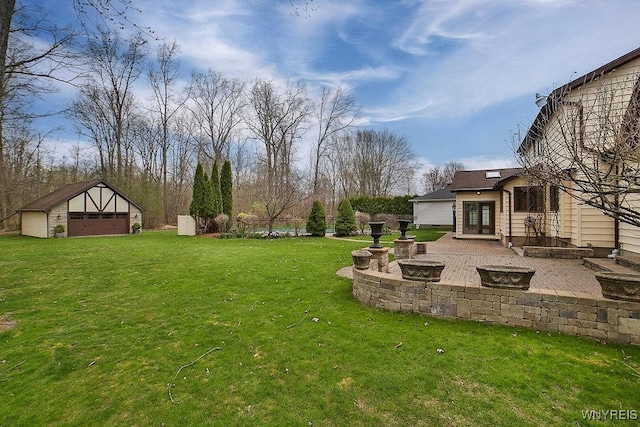view of yard featuring a patio, a fire pit, an outdoor structure, and a garage