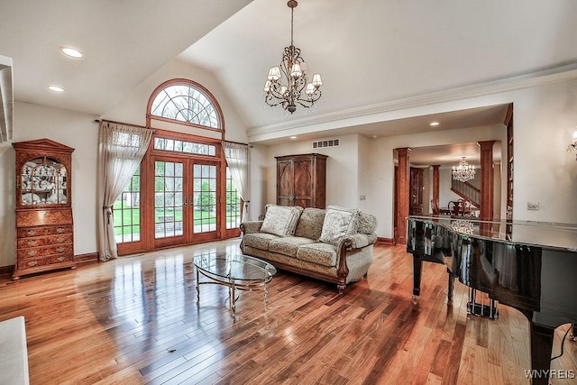 living room featuring french doors, visible vents, wood finished floors, baseboards, and a notable chandelier