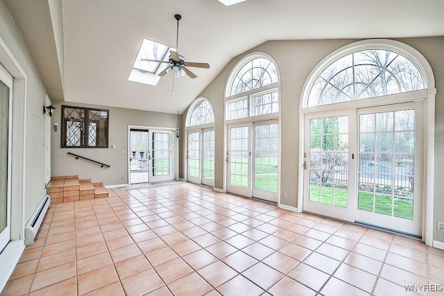 unfurnished sunroom with a skylight, a baseboard radiator, and french doors