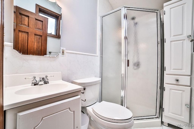 bathroom featuring vanity, a stall shower, and toilet