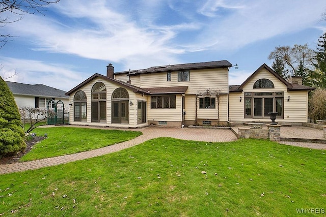 rear view of house featuring a patio, a lawn, fence, and a chimney
