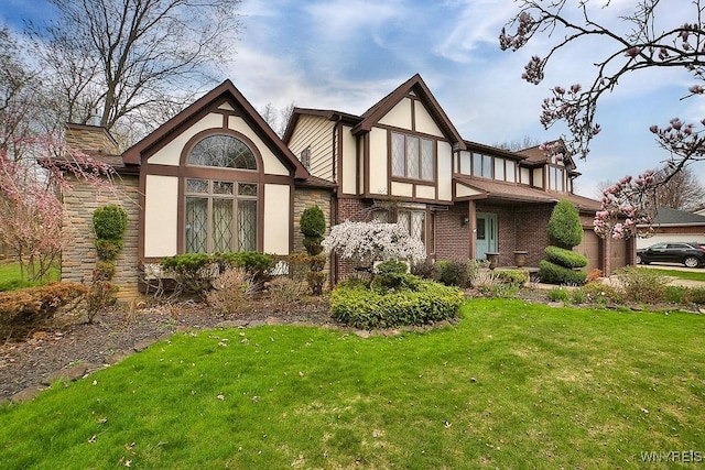 view of front of home with brick siding, a chimney, a front lawn, and stucco siding