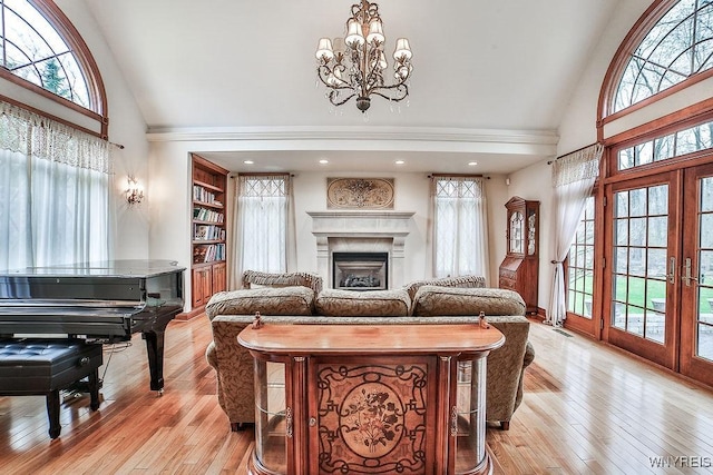 living room with plenty of natural light, a chandelier, and high vaulted ceiling