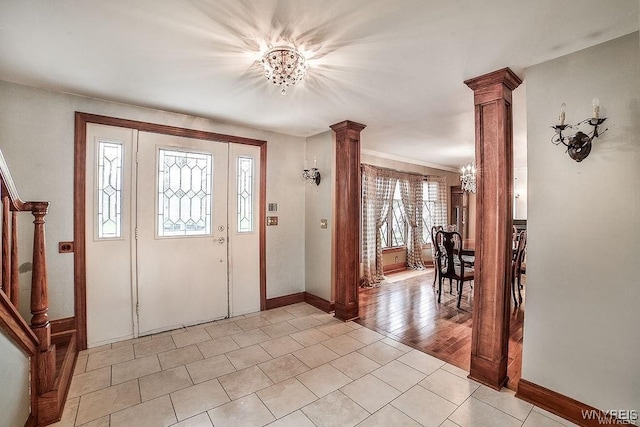 entryway featuring baseboards, stairway, ornate columns, a chandelier, and light tile patterned floors