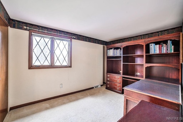 unfurnished office featuring baseboards, light carpet, and visible vents