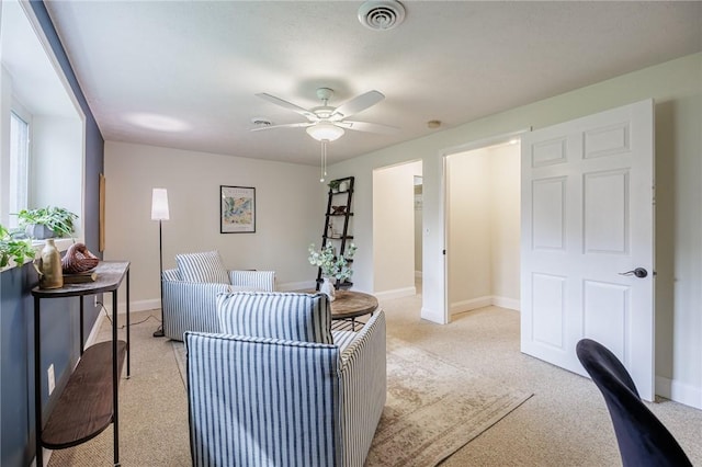 office area featuring baseboards, visible vents, a ceiling fan, and light colored carpet