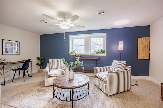 living area with visible vents, a ceiling fan, baseboards, and carpet flooring